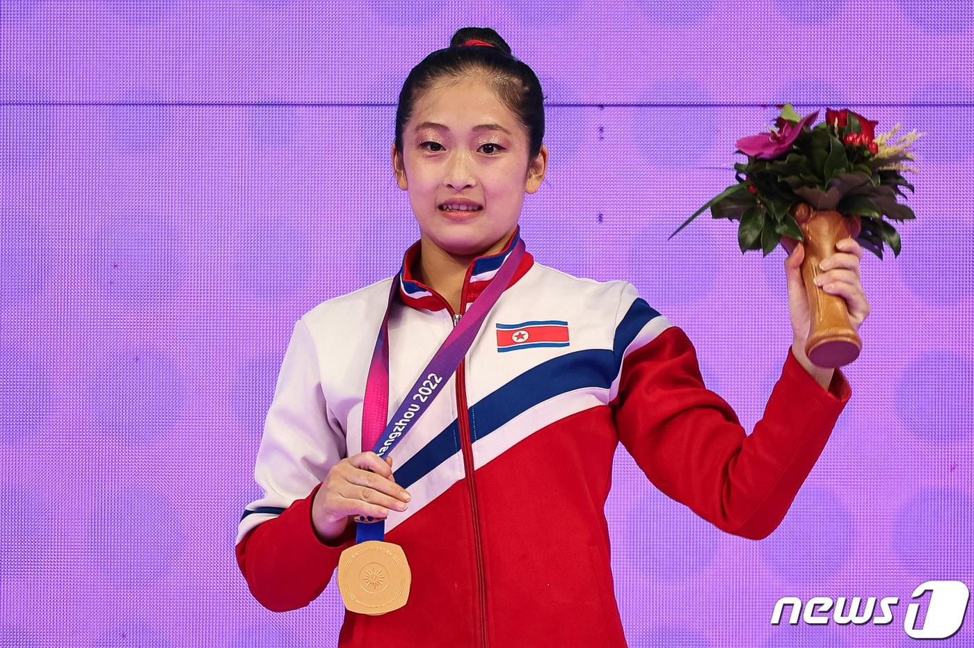 본문 이미지 - 지난해 9월28일 중국 항저우 황롱스포츠센터 체육관에서 열린 2022 항저우 아시안게임 기계체조 여자 도마 시상식에서 북한 기계체조 선수 안창옥이 금메달을 들고 포즈를 취하고 있다. /뉴스1 ⓒ News1 유승관 기자