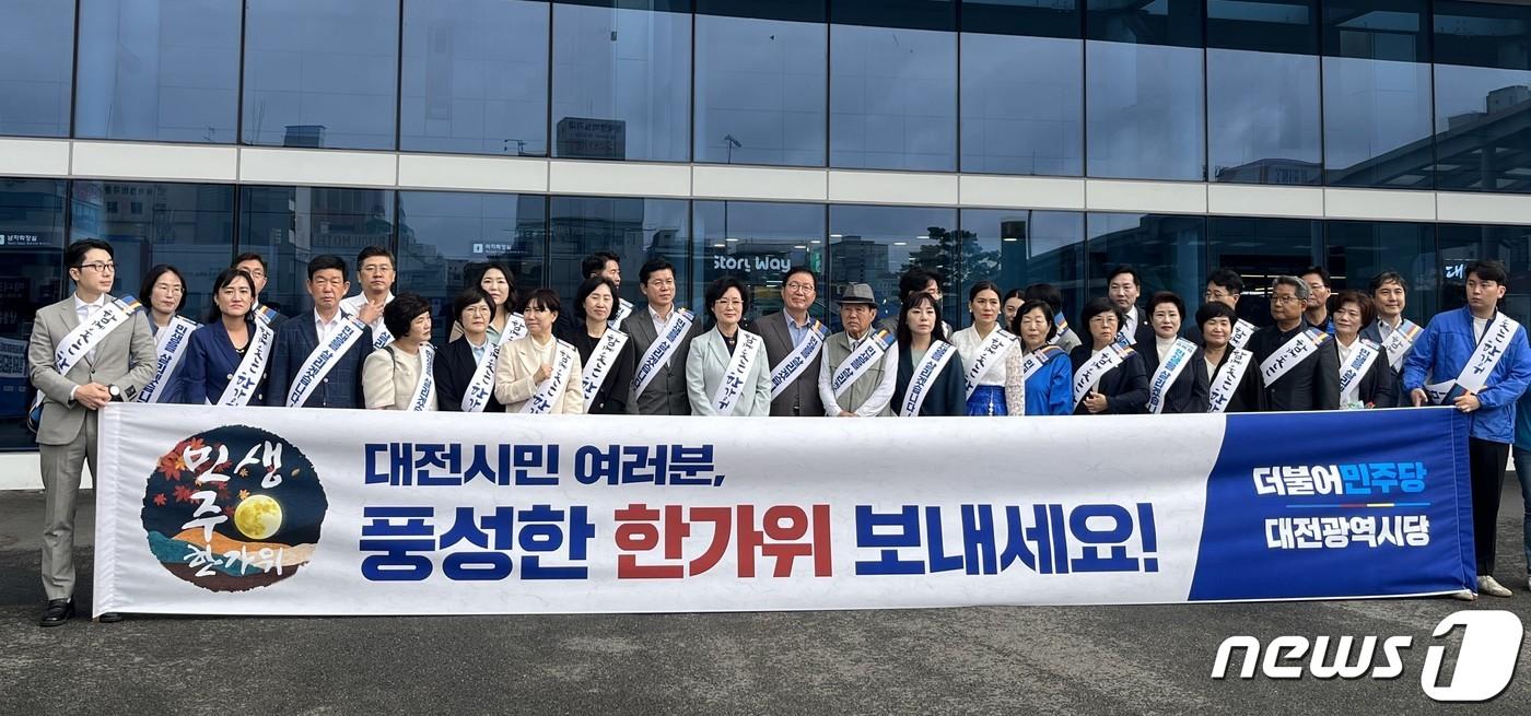 본문 이미지 - 추석을 맞아 27일 대전역에서 귀성 인사를 한 더불어민주당 당원들이 기념촬영을 하고 있다. (민주당 대전시당 제공) /뉴스1