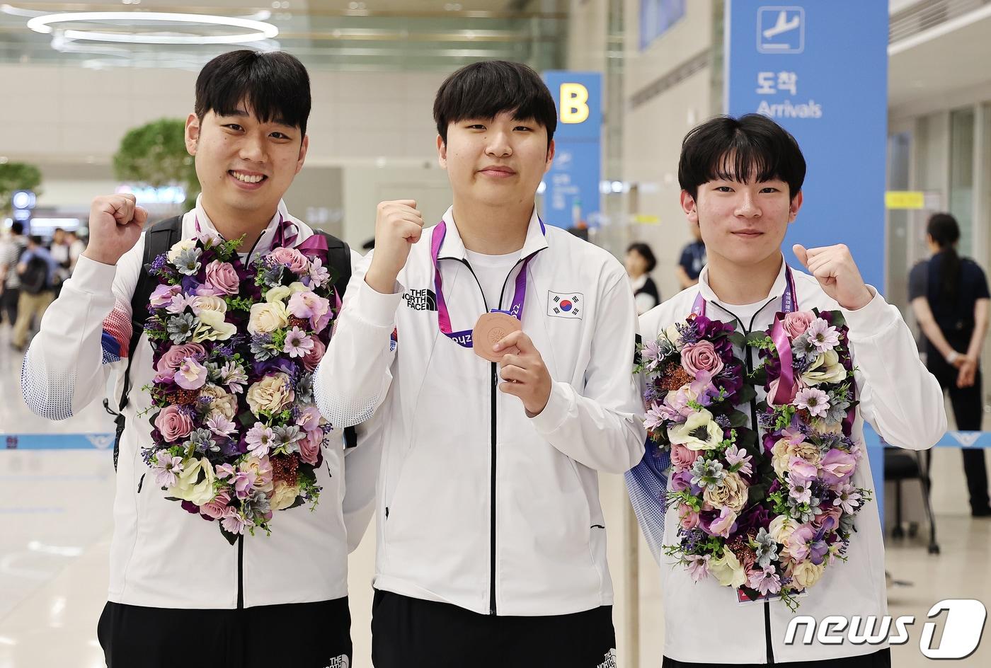 본문 이미지 - 항저우 아시안게임 e스포츠 ‘FC 온라인’ 대표팀의 신보석 감독(왼쪽부터), 동메달을 획득한 곽준혁, 박기영이 29일 오후 인천국제공항 제2터미널을 통해 귀국한 뒤 기념 촬영을 하고 있다.2023.9.29/뉴스1 ⓒ News1 김진환 기자
