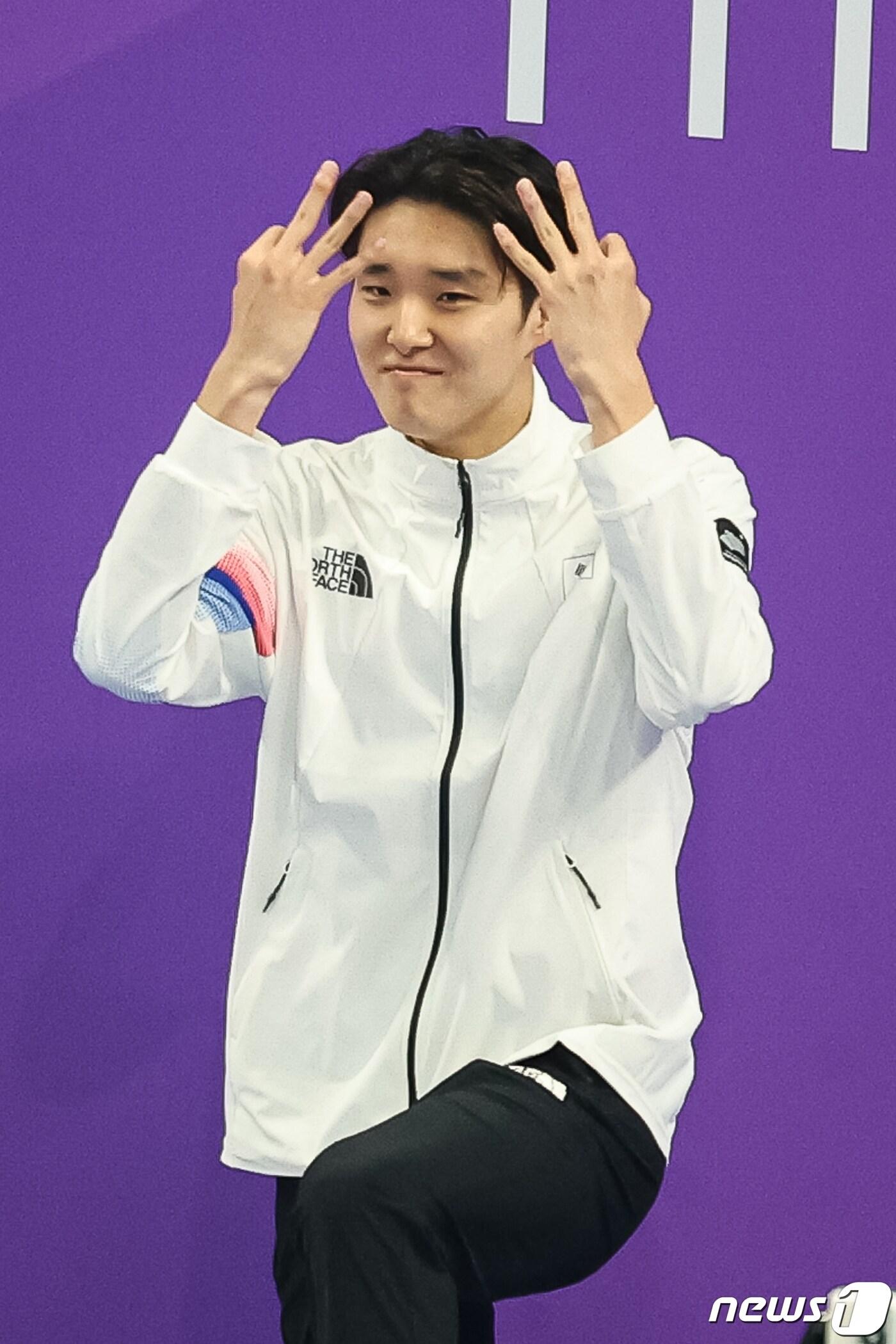 본문 이미지 - 김우민이 29일 중국 항저우 올림픽 스포츠센터 아쿠아틱스포츠 아레나에서 열린 2022 항저우 아시안게임 남자 자유형 400m 시상식에서 시상대에 오르며 3관왕을 의미하는 손가락 세 개를 들어보이고 있다. 2023.9.29/뉴스1 ⓒ News1 유승관 기자