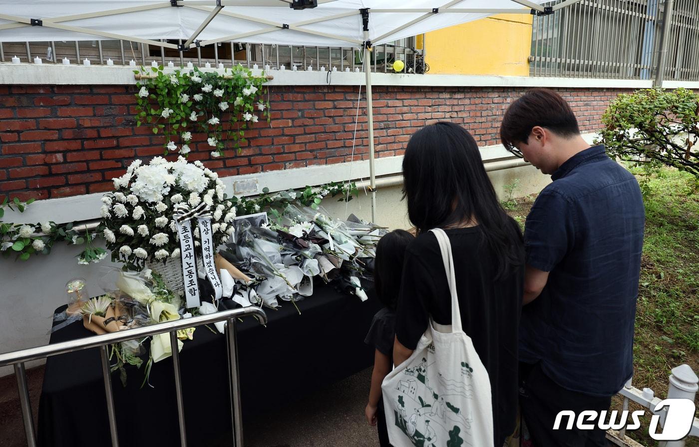 본문 이미지 - 사망한 서이초 교사의 49재를 하루 앞둔 3일 서울 서초구 서이초등학교 1학년 6반 교실 외벽에 설치된 추모공간을 찾은 한 가족이 고인이 된 교사를 추모하고 있다. 2023.9.3/뉴스1 ⓒ News1 박정호 기자