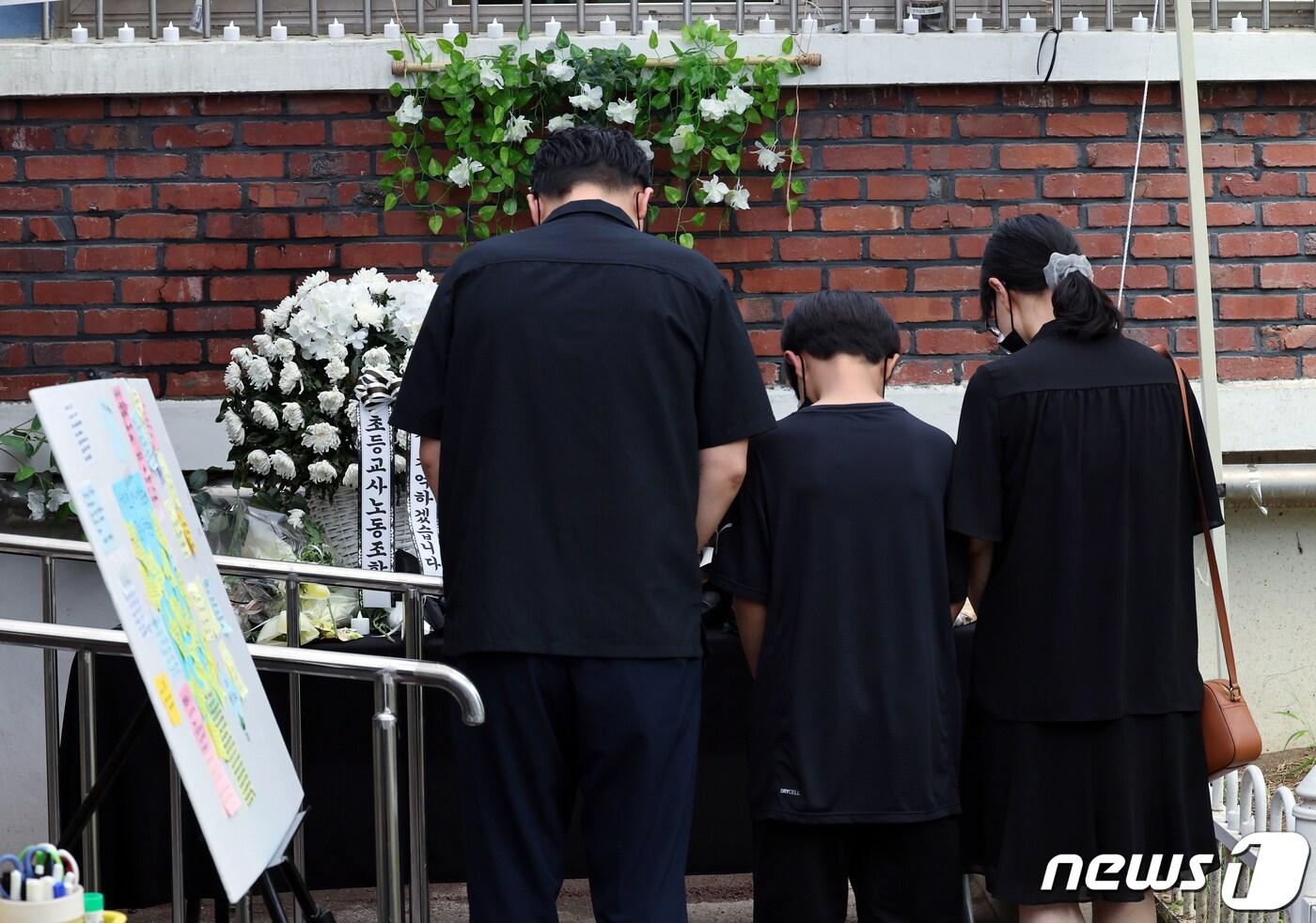 본문 이미지 - 사망한 서이초 교사의 49재를 하루 앞둔 3일 서울 서초구 서이초등학교 1학년 6반 교실 외벽에 설치된 추모공간을 찾은 한 가족이 고인이 된 교사를 추모하고 있다. 2023.9.3/뉴스1 ⓒ News1 박정호 기자