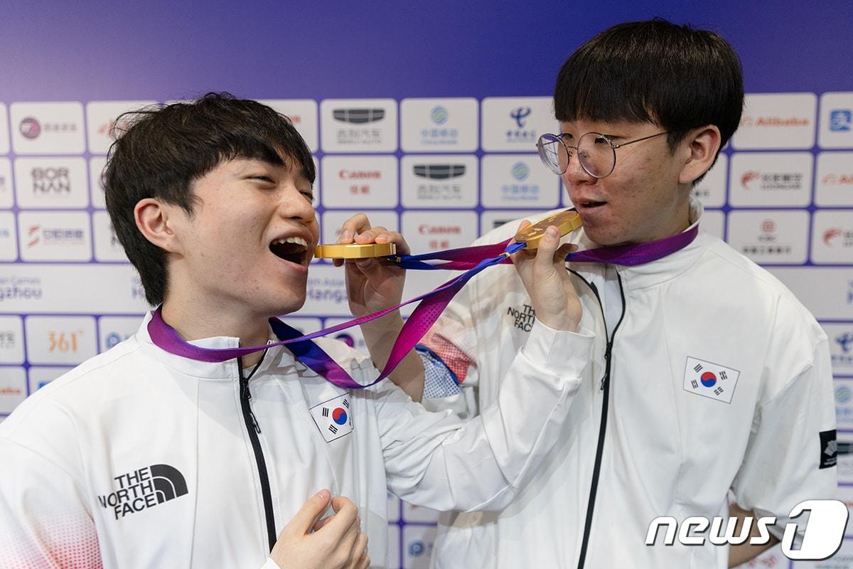 본문 이미지 - 29일 리그 오브 레전드 최종 결승전 후 믹스트존에서 서로에게 금메달을 먹여주고 있는 케리아와 룰러의 모습 2023.9.29/ⓒ공동취재단