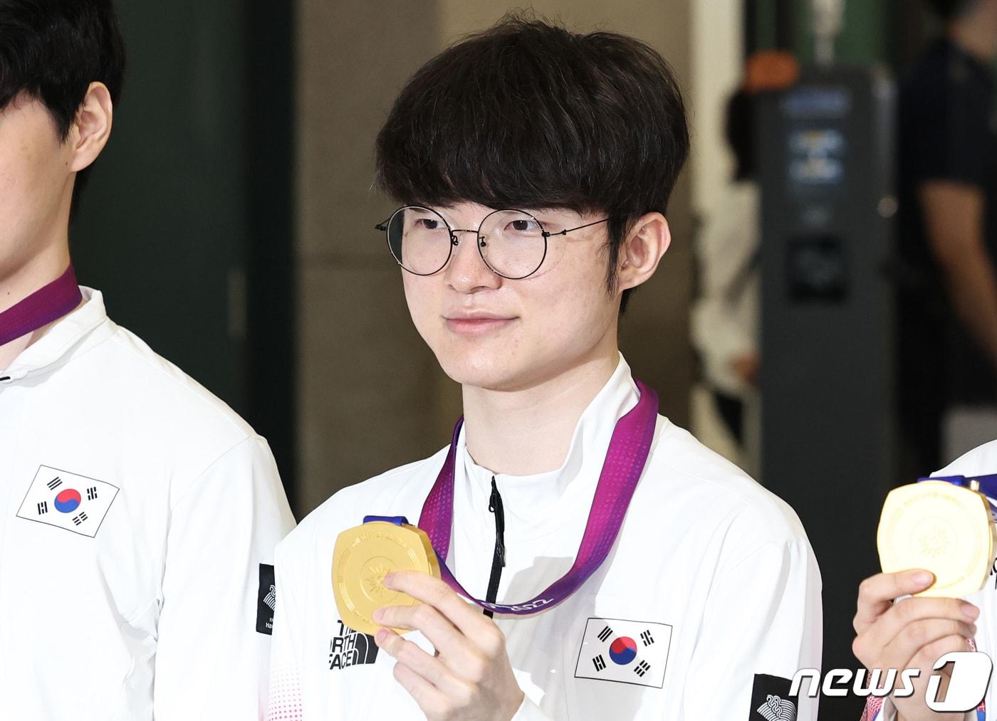 본문 이미지 - '2022 항저우 아시안게임' e스포츠 리그 오브 레전드(LoL)에서 금메달을 획득한 페이커 이상혁이 30일 인천국제공항 제1여객터미널을 통해 귀국해 메달을 들어보이고 있다. 2023.9.30/뉴스1 ⓒ News1 구윤성 기자