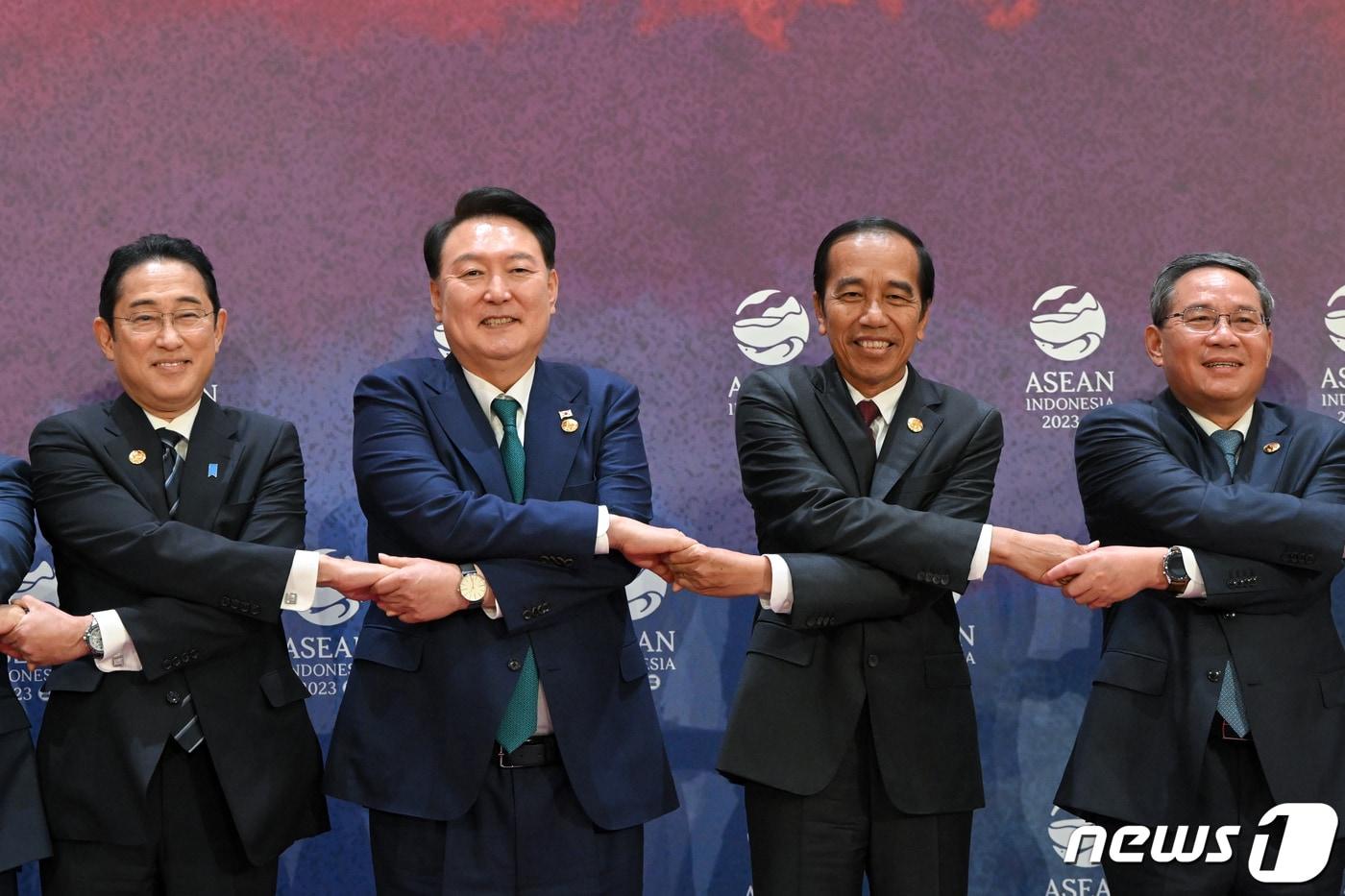본문 이미지 - 윤석열 대통령이 6일(현지시간) 자카르타 컨벤션센터에서 열린 아세안(동남아시아국가연합)+3 정상회의에서 각국 정상들과 손을 맞잡은 채 기념촬영을 하고 있다. 왼쪽부터 기시다 후미오 일본 총리, 윤 대통령, 조코 위도도 인도네시아 대통령, 리창 중국 총리. (대통령실 제공) 2023.9.6/뉴스1 ⓒ News1 오대일 기자