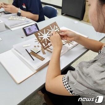 본문 이미지 - 삼화페인트 임직원 봉사단이 시각장애 아동을 위한 특수도서 제작 봉사활동에 참여하고 있다. (삼화페인트 제공)