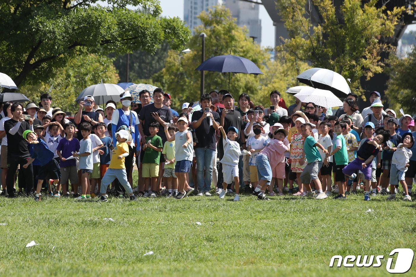 본문 이미지 - '2023 한강 종이비행기 축제'에 참가한 어린이들이 종이 비행기를 날리고 있다/뉴스1 ⓒ News1 이승배 기자
