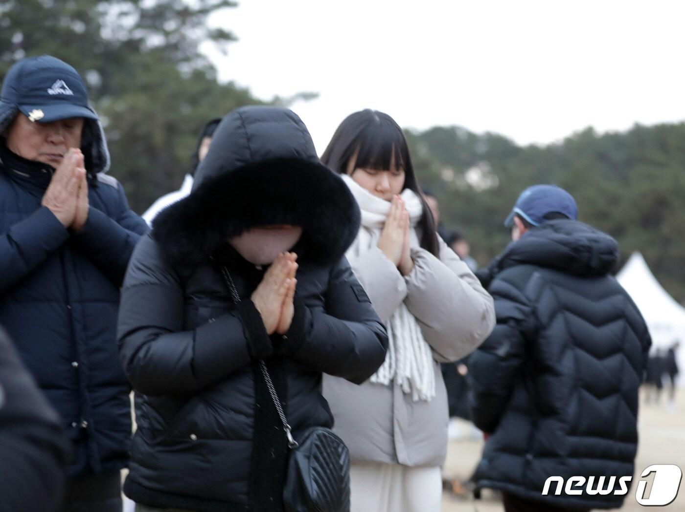 본문 이미지 - 2024년 갑진년 해돋이를 보기 위해 간절곶을 찾았던 시민들이 구름 뒤에 가린 해를 향해 새해 소망을 빌고 있다.2024.1.1/뉴스1 ⓒ News1 김지혜기자