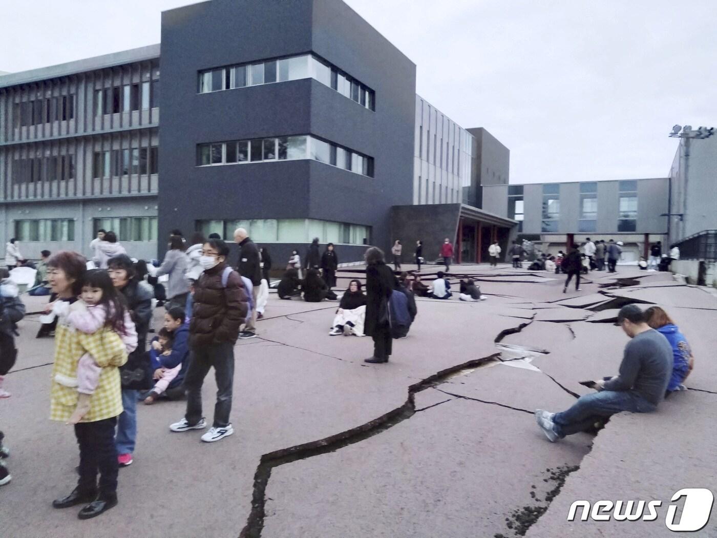 본문 이미지 - 일본 혼슈(本州)의 동해 연안에 있는 이시카와현에서 1일 오후 4시10분쯤 규모 7.6 강진이 발생한 가운데 와지마시 주민들이 밖으로 대피해 있다. 지진으로 건물 밖 도로가 갈라져 있다. 2024.01.01 ⓒ 로이터=뉴스1 ⓒ News1 최종일 기자