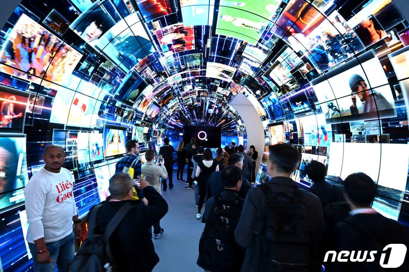본문 이미지 - 8일(현지시간) 미국 라스베이거스에서 열린 세계 최대 전자 전시회 'CES 2024' LG전자 부스를 찾은 관람객들이 올레드 디스플레이 140여 대를 이어 붙인 터널 구조의 체험 공간에서 LG전자 스마트 TV 플랫폼 'webOS'의 다양한 콘텐츠들을 체험하고 있다. (LG전자 제공) 2024.1.10/뉴스1