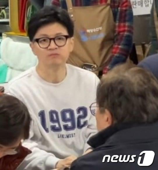 본문 이미지 - 2024년 1월 11일 한동훈 국민의힘 비대위원장이 롯데 자이언츠가 마지막으로 한국시리즈에서 우승한 1992년이 적힌 옷을 입고 부산 중구 남포동 자갈치시장에서 저녁 식사를 하고 있는 모습. (온라인커뮤니티 갈무리) 2024.01.11 ⓒ 뉴스1