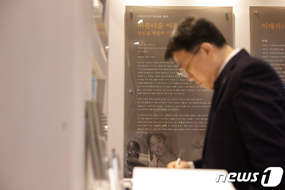 본문 이미지 - 11일 백인제기념도서관 로비에 위치한 이태석신부기념실에서 추모 후 방명록을 작성하고 있는 인제대 전민현 총장. (인제대 제공)