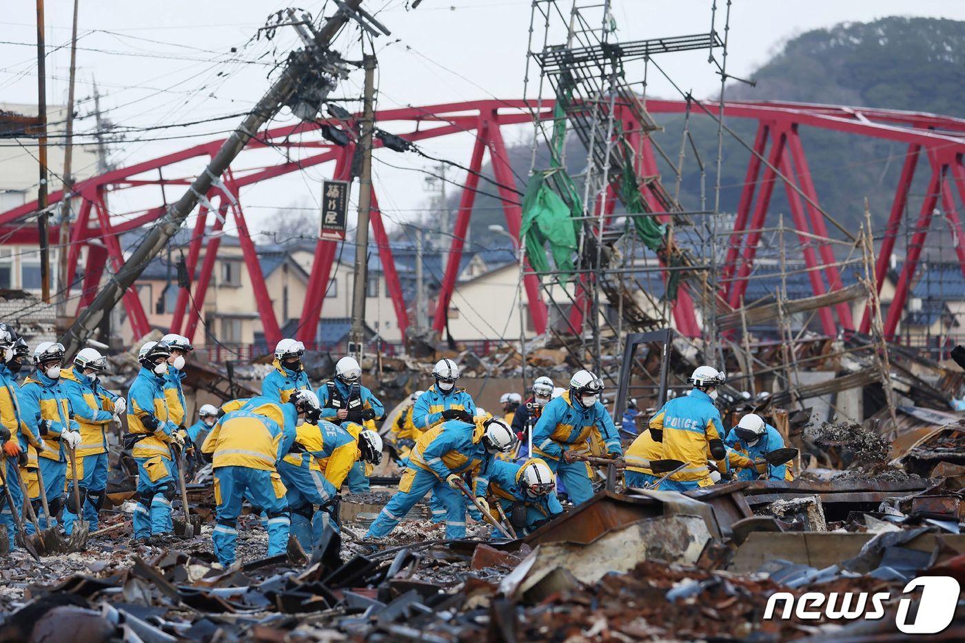 본문 이미지 - 최근 일본 이시카와현에서 발생한 지진으로 파괴된 와지마 지역 피해 현장에 경찰관들이 나와 복구 작업을 수행하고 있다. 2024.01.12 ⓒ AFP=뉴스1 ⓒ News1 정지윤 기자