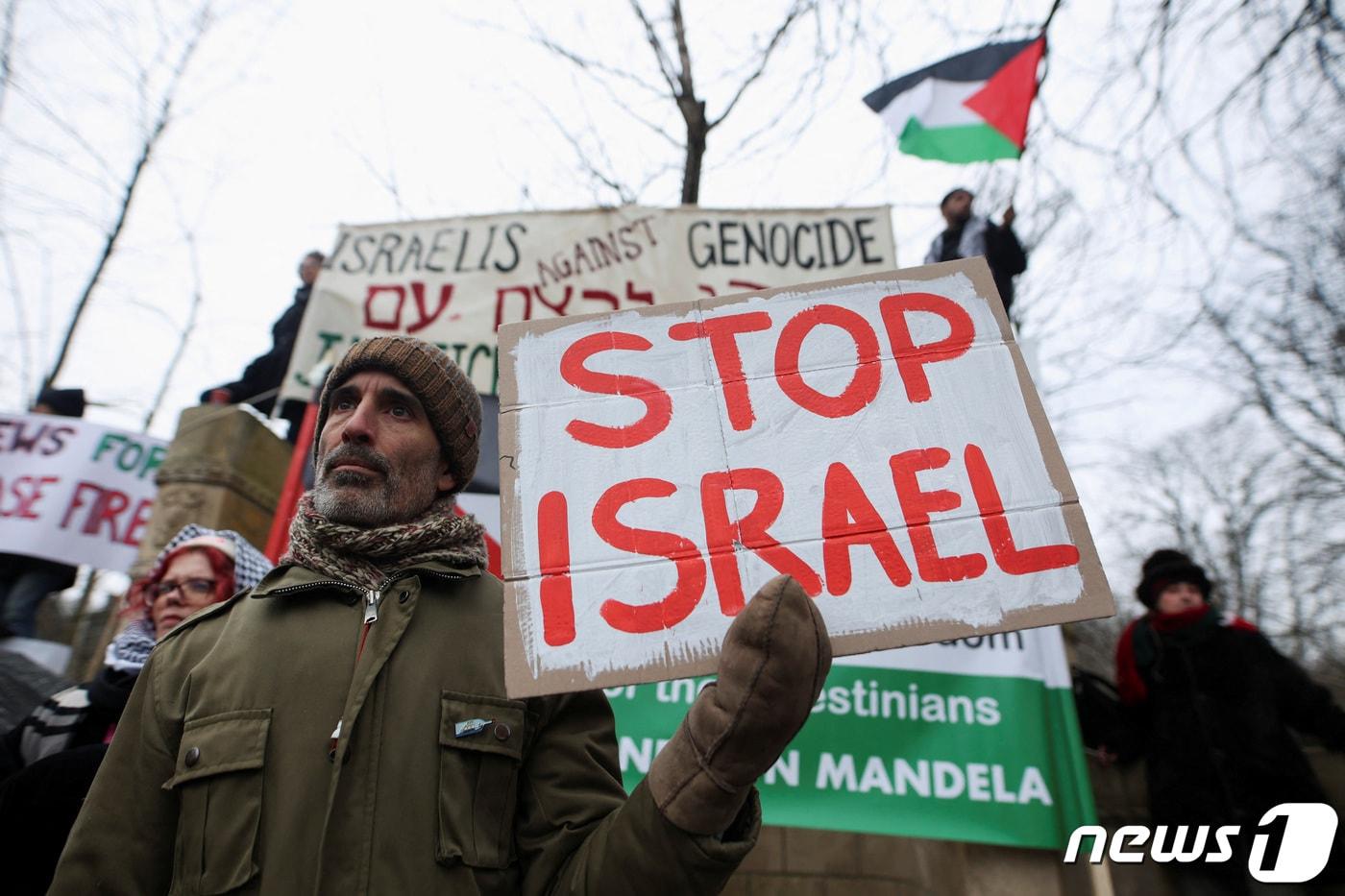 11일(현지시간) 네덜란드 헤이그에서 집회자들이 "이스라엘을 멈춰라＂는 플래카드를 들고 시위하고 있다. 이날 국제사법재판소(ICJ)에서는 이스라엘의 가자지구 내 집단학살 혐의에 대한 청문회가 열렸다. 2024.01.11/ ⓒ 로이터=뉴스1 ⓒ News1 권진영 기자