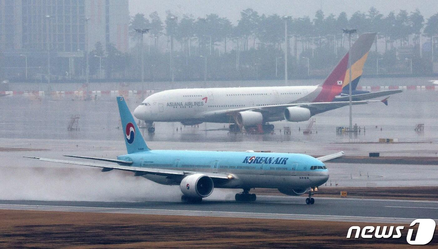 14일 오후 인천국제공항에서 대한항공 항공기가 아시아나 항공기 앞으로 이륙하고 있다. 2024.1.14/뉴스1 ⓒ News1 장수영 기자