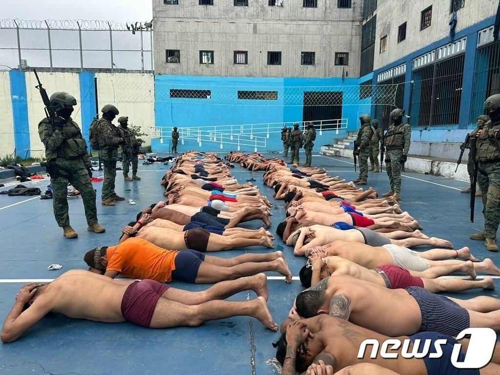 본문 이미지 - 14일(현지시간) 에콰도르 쿠엥카의 투리 교도소에서 무장한 군인들이 수감자들을 제압한 뒤 교도소 안을 수색하고 있다. 2024.01.14 ⓒ AFP=뉴스1 ⓒ News1 정지윤 기자