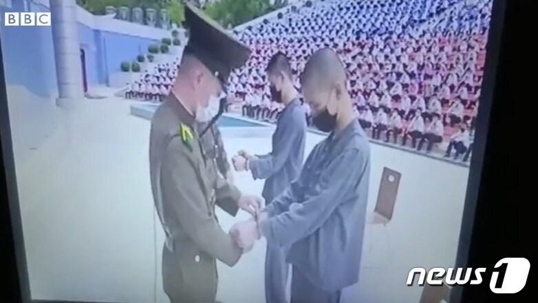 본문 이미지 -  북한이 한국 드라마를 시청했다는 이유로 10대 소년 2명에 대해 12년의 노동교화형을 선고하고 수갑을 채우고 있다. (영국 BBC 방송이 공개한 샌드연구소 영상 갈무리)