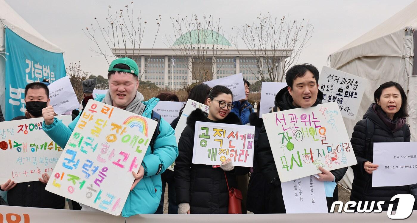 장애인 인권 단체 회원들이 2일 서울 여의도 국회 앞에서 가진 기자회견에서 장애인 참정권 보장을 촉구하고 있다. 이들은 모든 사람이 접근 가능한 투표소 선정과 수어통역·자막 제공 의무화, 이해하기 쉬운 선거 정보 제공 등을 22대 총선에서 제공할 것을 국회에 촉구했다. 2024.1.2/뉴스1 ⓒ News1 신웅수 기자