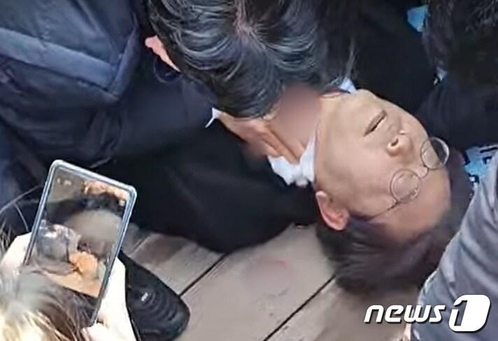 본문 이미지 - 이재명 더불어민주당 대표가 지난해 1월 2일 오전 부산 가덕도에서 신원미상인에게 습격을 당한 뒤 쓰러져 있다. (유튜브 정양일 TV 갈무리) ⓒ 뉴스1