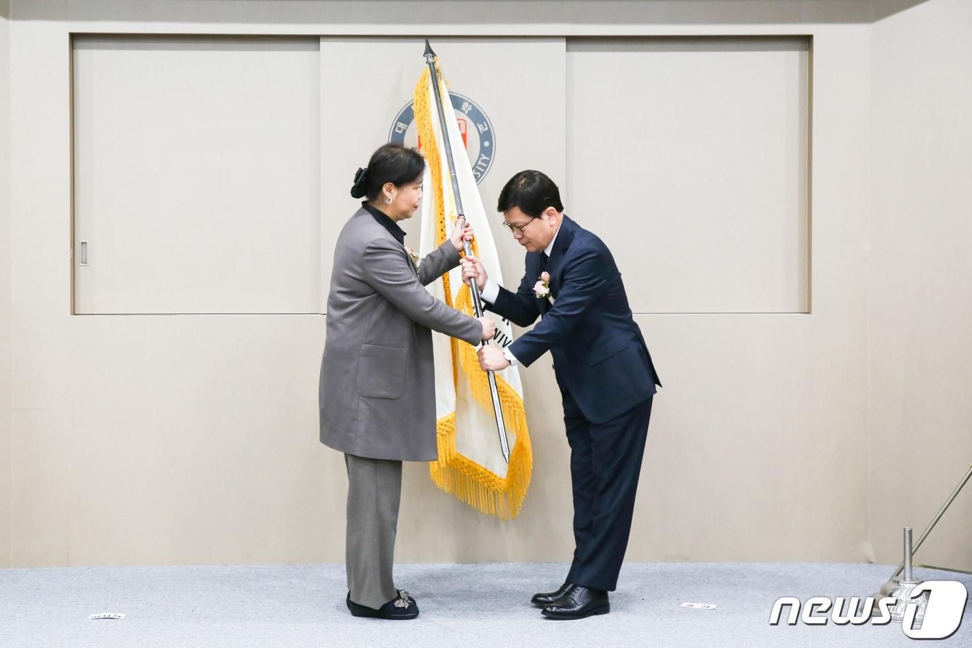 임정섭 창성학원 이사장(왼쪽)이 김대성 대덕대 신임 총장에게 교기를 전달하고 있다.(대덕대 제공)/뉴스1 