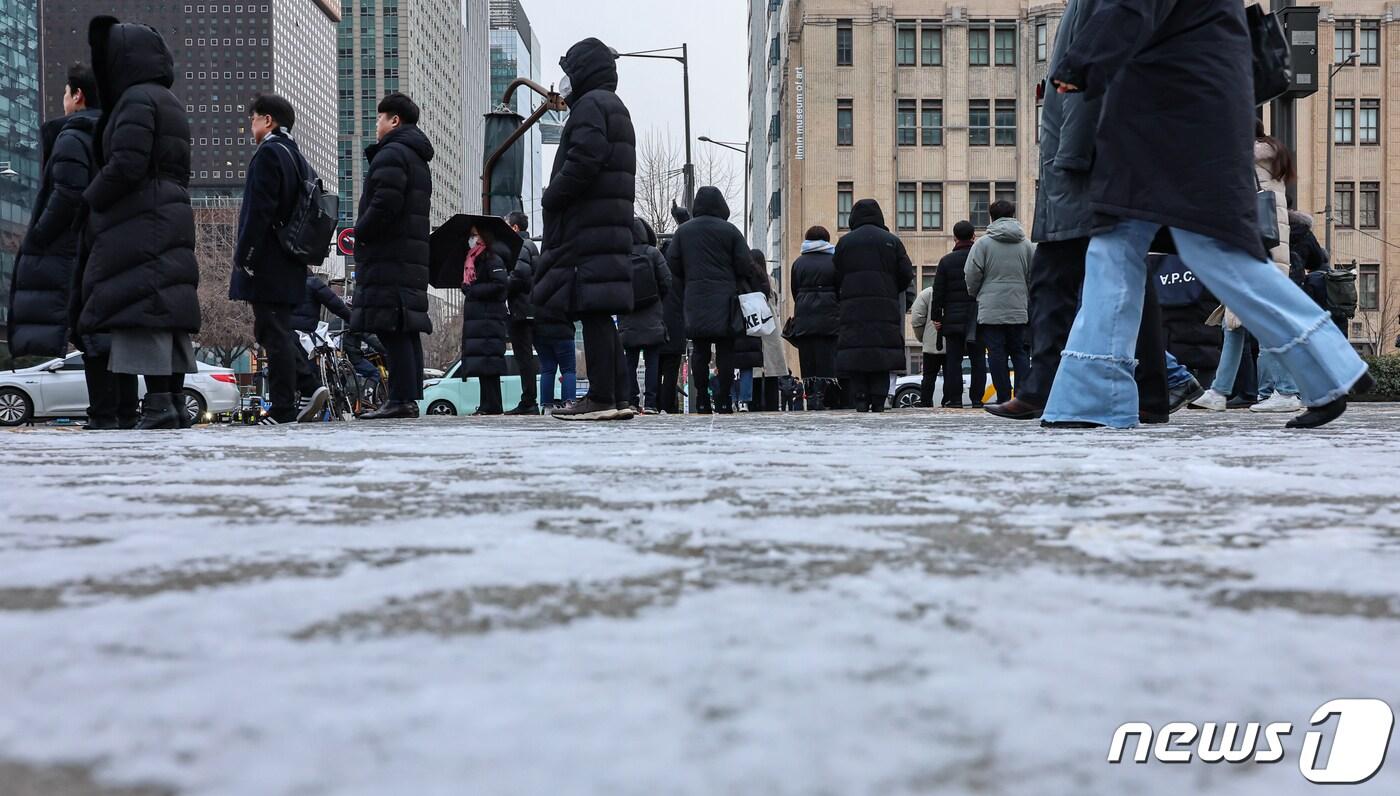 본문 이미지 - 서울 등 수도권 지역에 한파주의보 내려진 22일 오전 서울 종로구 광화문 네거리에서 시민들이 밤 사이 내린 눈 위를 지나가고 있다. 2024.1.22/뉴스1 ⓒ News1 김도우 기자