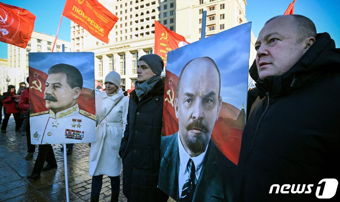 21일(현지시간) 러시아 공산주의 지지자들이 러시아 모스크바 붉은 광장에 있는 블라디미르 레닌의 묘소 앞에서 블라디미르 레닌(오른쪽)의 초상화를 들고 추모식에 참석하고 있다. 2024.01.21 ⓒ AFP=뉴스1 ⓒ News1 정지윤 기자