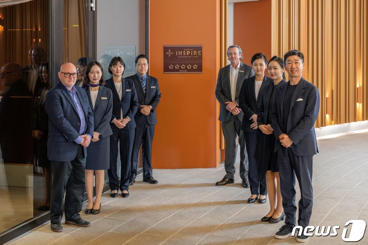 본문 이미지 - 모히건 및 모히건 인스파이어의 임직원들이 5성 호텔 등급 현판식 후 기념촬영을 하고 있다. 레이 피널트 CEO(왼쪽 첫번째),  전영기 호텔GM(네번째), 웨이크 하우크 COO(다섯번째), 첸 시 사장(여덟번째)(모히건 인스파이어 제공)