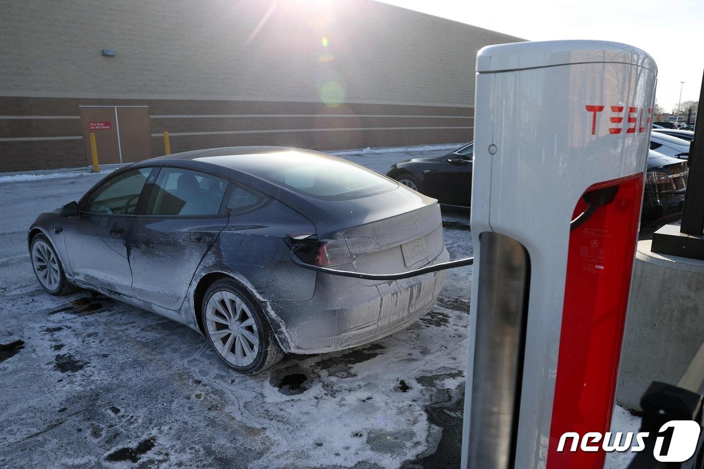 본문 이미지 - 17일(현지시간) 한파가 들이닥친 미국 일리노이주 시카고에서 한 테슬라 차량이 얼음으로 덮인 주차장에서 배터리를 충전하고 있다. ⓒ AFP=뉴스1 ⓒ News1 박주평 기자