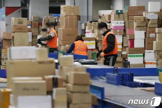 본문 이미지 - 서울 금천구 CJ대한통운택배 서울지사서 분류 작업자들이 택배를 옮기고 있다. 2022.1.19/뉴스1 ⓒ News1 민경석 기자 