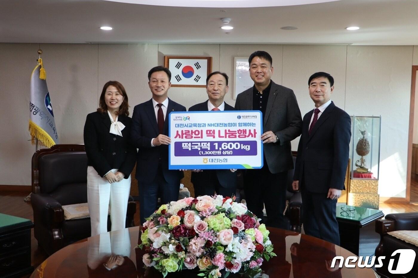 본문 이미지 - 대전농협 사회봉사단 이재윤 공동위원장(왼쪽 두번째)과 권희근 공동위원장(오른쪽 두번째)이 떡국 떡을 설동호 대전시교육감(가운데)에게 전달한 후 기념사진을 찍고 있다.(농협 대전본부 제공) / 뉴스1