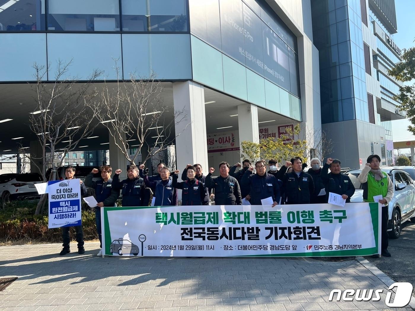 본문 이미지 - 민주노총 경남본부가 29일 경남 창원 더불어민주당 경남도당 당사 앞에서 기자회견을 열고 경남도에 택시 월급제 시행 매뉴얼 마련을 촉구하고 있다.(민주노총 경남본부 제공)