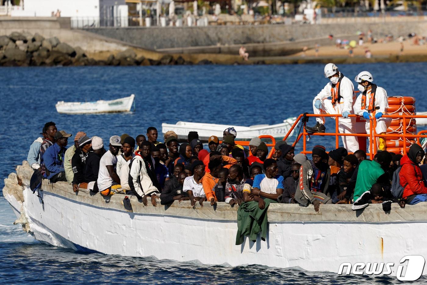 2일(현지시간) 스페인 크란카나리아섬의 아귀네긴 항구에서 한 무리의 이주민들이 스페인 해안경비대 선박에 의해 구조된 후 나무배에서 내리기를 기다리고 있다. 2024.01.02 ⓒ 로이터=뉴스1 ⓒ News1 정지윤 기자