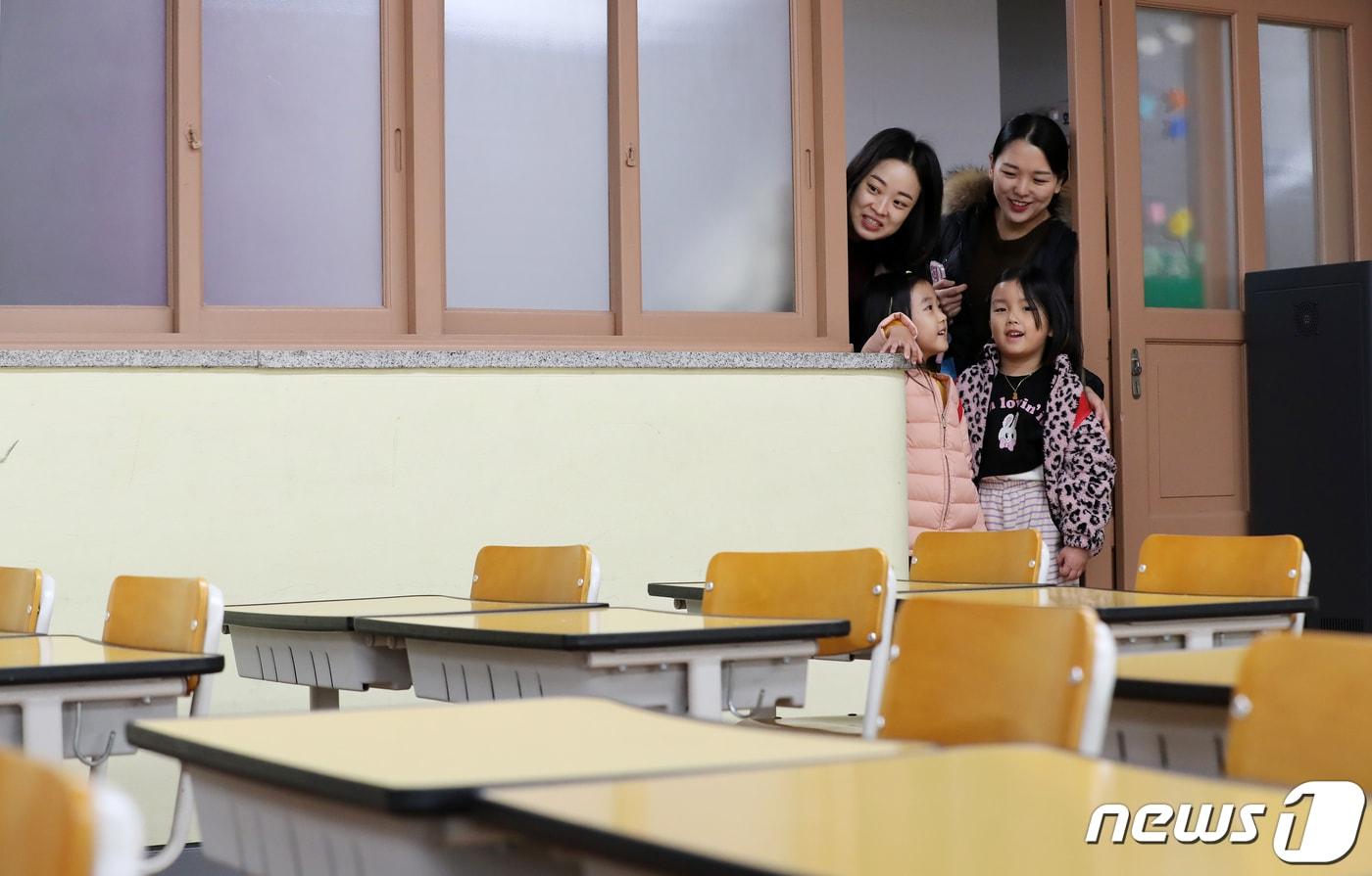 본문 이미지 - 2024학년도 신입생 예비소집에서 예비 신입생들과 학부모가 1학년 교실을 살펴보고 있다. ⓒ News1 윤일지 기자