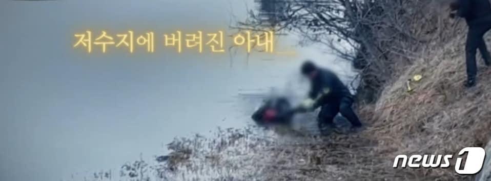 본문 이미지 -  2023년 1월 31일 충남 태안 고남저수지를 수색하던 경찰이 시신이 들어있는 가방을 물밖으로 옮기는 모습. (SBS 갈무리) ⓒ 뉴스1
