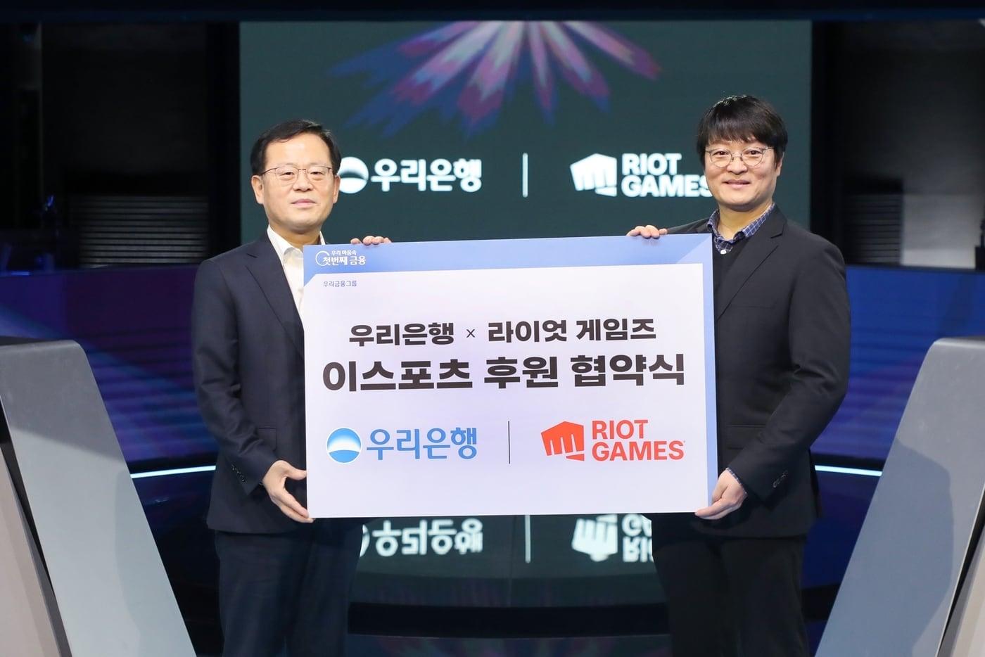 본문 이미지 - 지난 30일 종로구 롤파크 이스포츠 경기장에서 진행된 이스포츠 후원 협약식에서 조병규 우리은행장(왼쪽)과 조혁진 라이엇 게임즈 코리아 대표가 기념사진을 촬영하고 있다.(우리은행 제공)