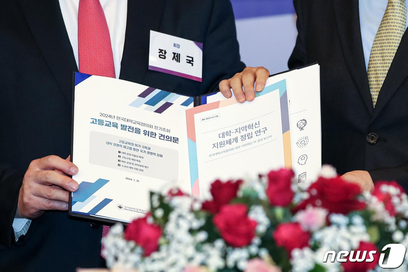 서울 서초구 더케이 호텔에서 지난해 1월 31일 열린 &#39;2024 한국대학교육협의회&#40;대교협&#41;&#39; 정기총회에서 장제국 당시 대교협 회장이 이주호 사회부총리 겸 교육부 장관에게 대정부 건의문을 전달하고 있다. 건의문에는 등록금을 올리면 국가장학금을 받을 수 없도록 하는 규제 폐지, 소규모 대학 국가적 정책 지원 등의 내용이 담겨있다. /뉴스1 ⓒ News1 이승배 기자