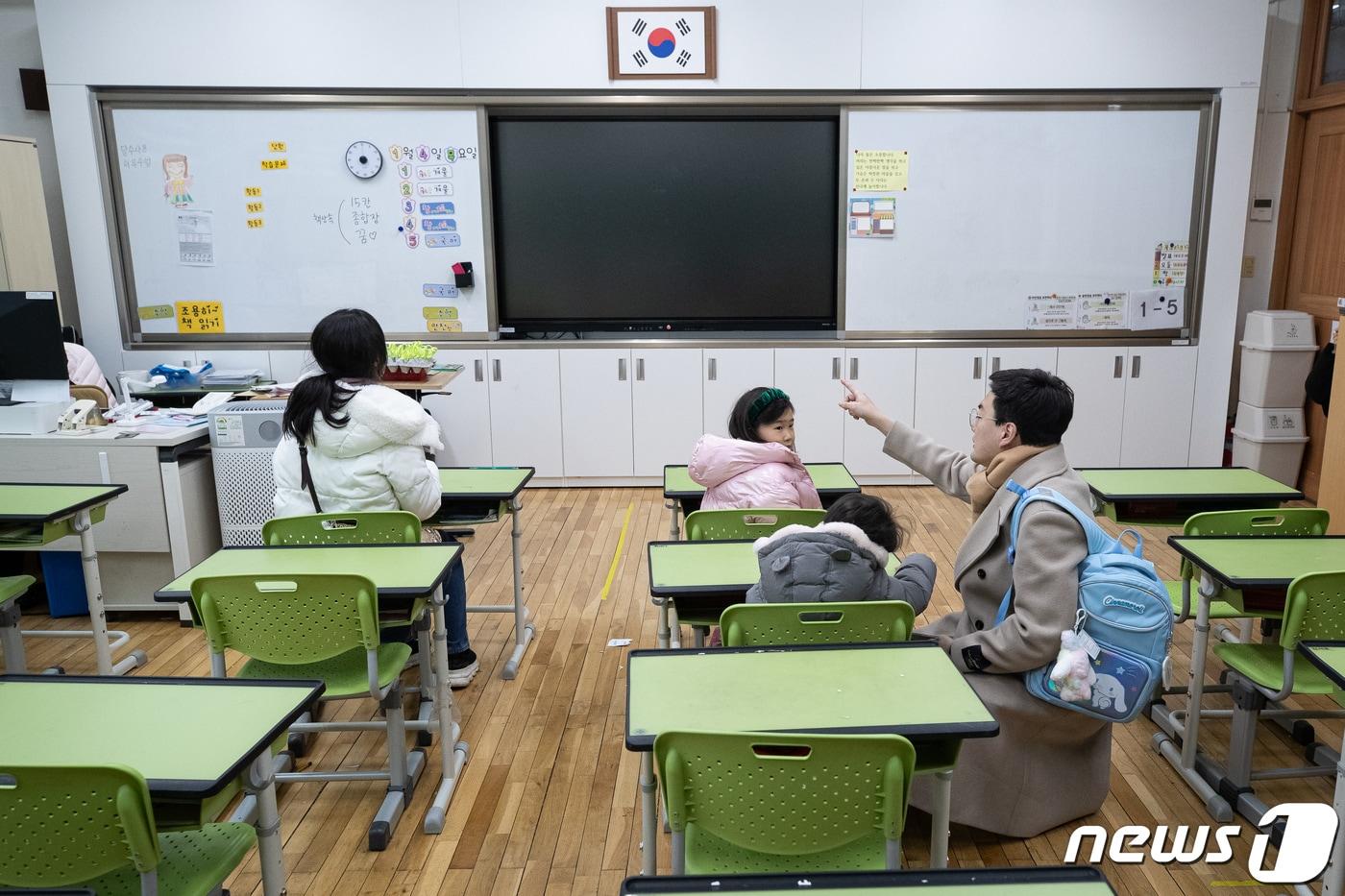 본문 이미지 - 서울 서초구의 한 학교에서 2024학년도 초등학교 신입생 예비소집에 참석한 한 신입생 가족이 교실을 둘러보고 있다. /뉴스1 ⓒ News1 유승관 기자