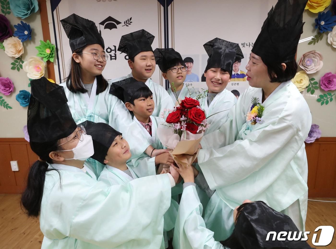 본문 이미지 - 5일 오전 경기 용인시 처인구 남곡초등학교 제2캠퍼스에서 6학년 1반 학생들이 졸업식을 마치고 담임선생님과 기념촬영을 하고 있다. 남곡초등학교 남곡분교는 이날 졸업하는 8명의 학생을 끝으로 폐교된다. 2024.1.5/뉴스1 ⓒ News1 김영운 기자