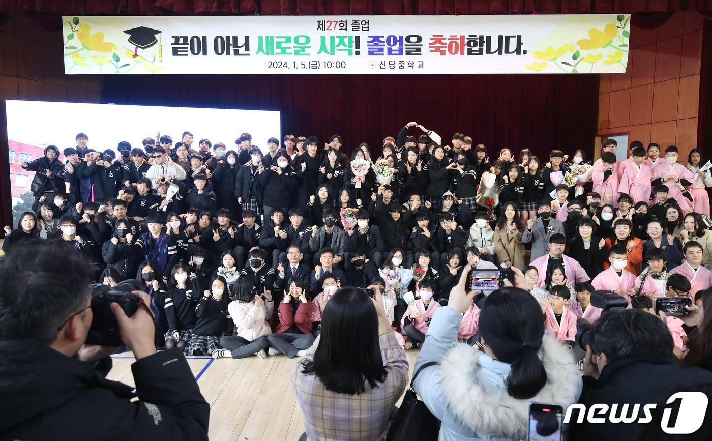 본문 이미지 - 지난 5일 대구 달서구 신당중학교 강당에서 제27회 마지막 졸업식을 마친 졸업생과 재학생들이 기념촬영을 하고 있다. 1995년 개교한 신당중학교는 계속되는 학생 수 감소에 따라 이날 마지막 졸업생 61명(총 7693명)을 배출한 뒤 2024년 3월1일자로 인근 학교와 통폐합된다. 2024.1.5/뉴스1 ⓒ News1 공정식 기자