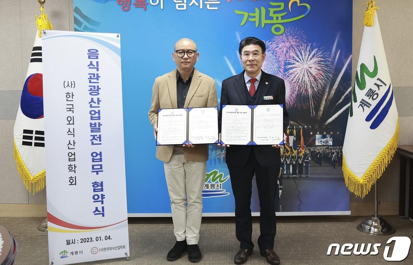 이응우 계룡시장(오른쪽)이 이걸재 한국외식산업학회장과 업무협약을 체결한 후 기념촬영을 하고 있다. (계룡시 제공) /뉴스1