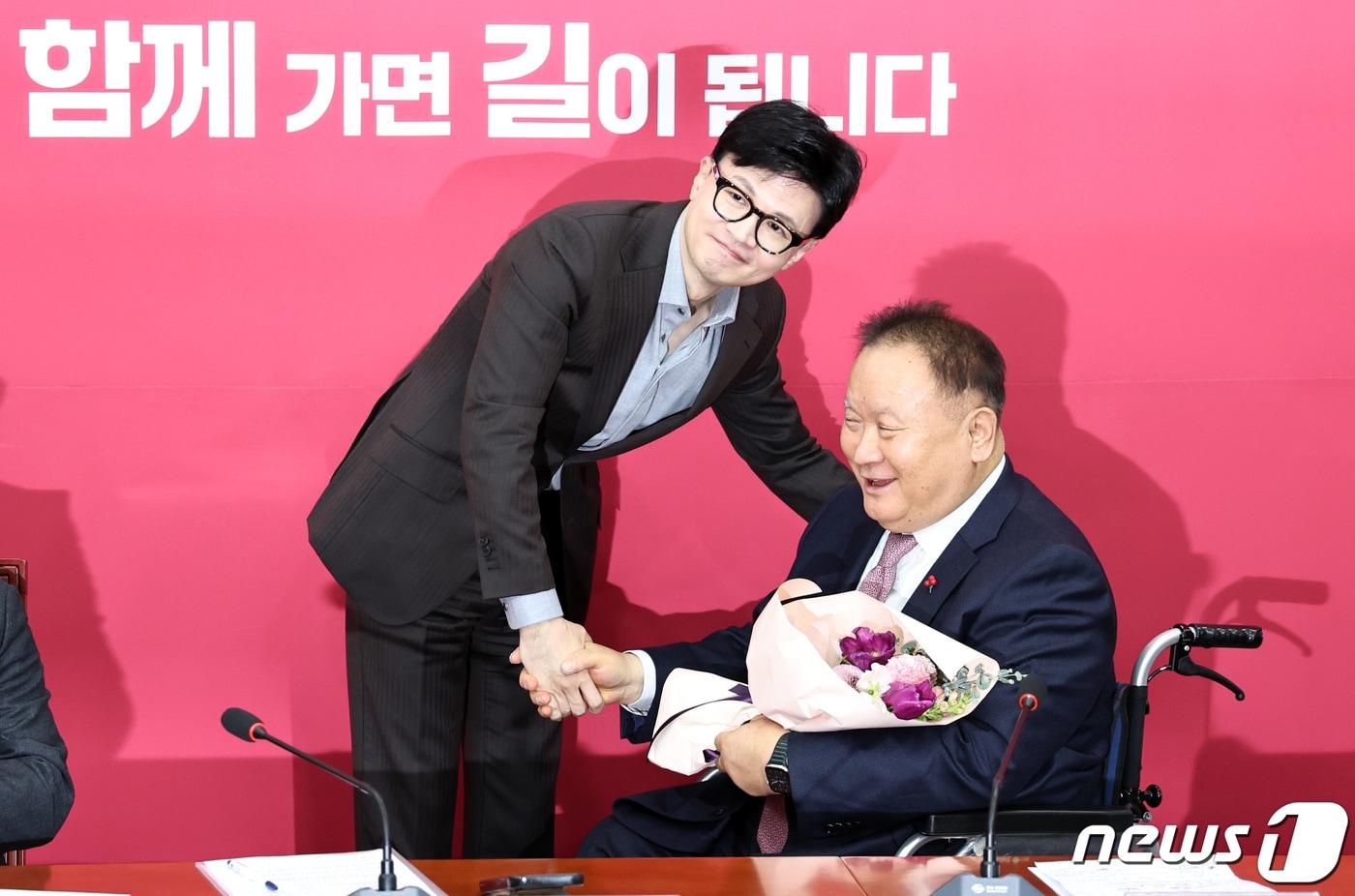 본문 이미지 - 한동훈 국민의힘 비상대책위원장이 8일 오전 서울 여의도 국회에서 열린 비대위 회의에서 국민의힘에 새로 입당한 이상민 의원에게 환영 꽃다발을 전달한 뒤 기념촬영을 하고 있다. 2024.1.8/뉴스1 ⓒ News1 구윤성 기자