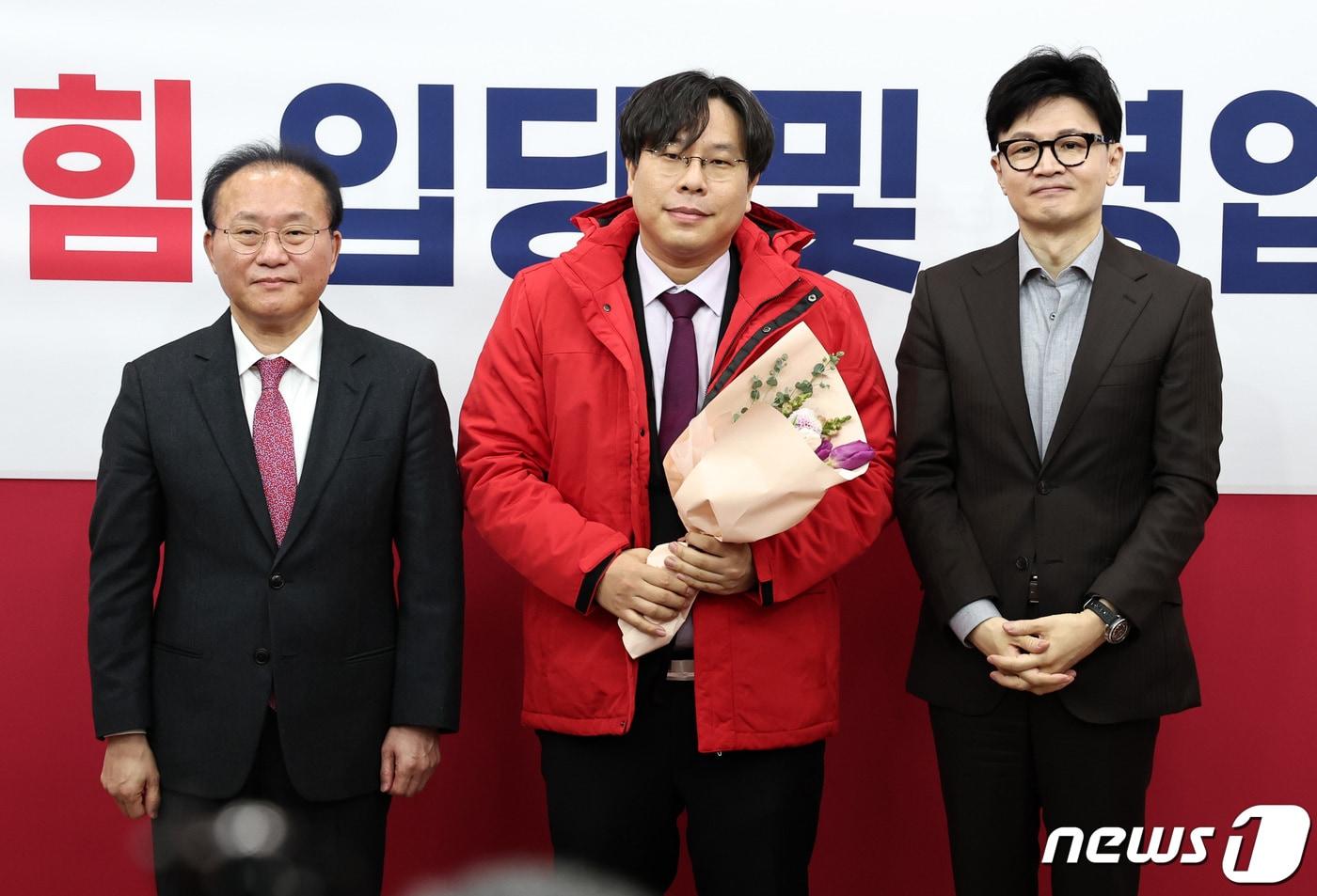 한동훈 전 국민의힘 비상대책위원장과 윤재옥 전 원내대표가 서울 여의도 국회에서 열린 국민의힘 인재영입위원회 입당 및 영입 환영식에서 학교폭력 전문 변호사인 박상수 변호사에게 당 점퍼를 입혀준 뒤 기념촬영을 하고 있다. 2024.1.8/뉴스1 ⓒ News1 구윤성 기자