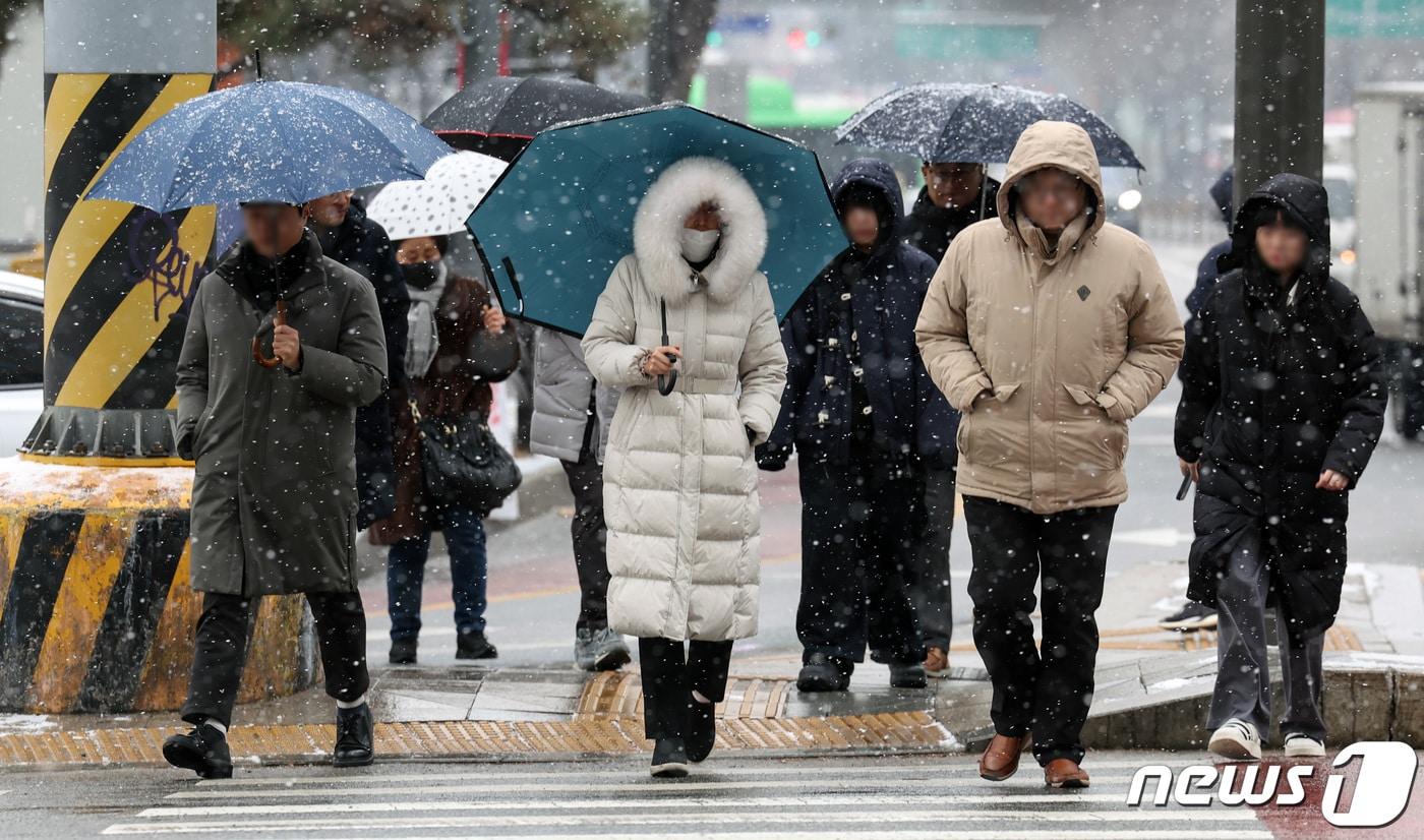 본문 이미지 - 수도권 전역에 대설주의보가 내려진 9일 오후 서울 종각연 인근에서 시민들이 우산을 쓰고 걷고 있다. 2024.1.9/뉴스1 ⓒ News1 김민지 기자