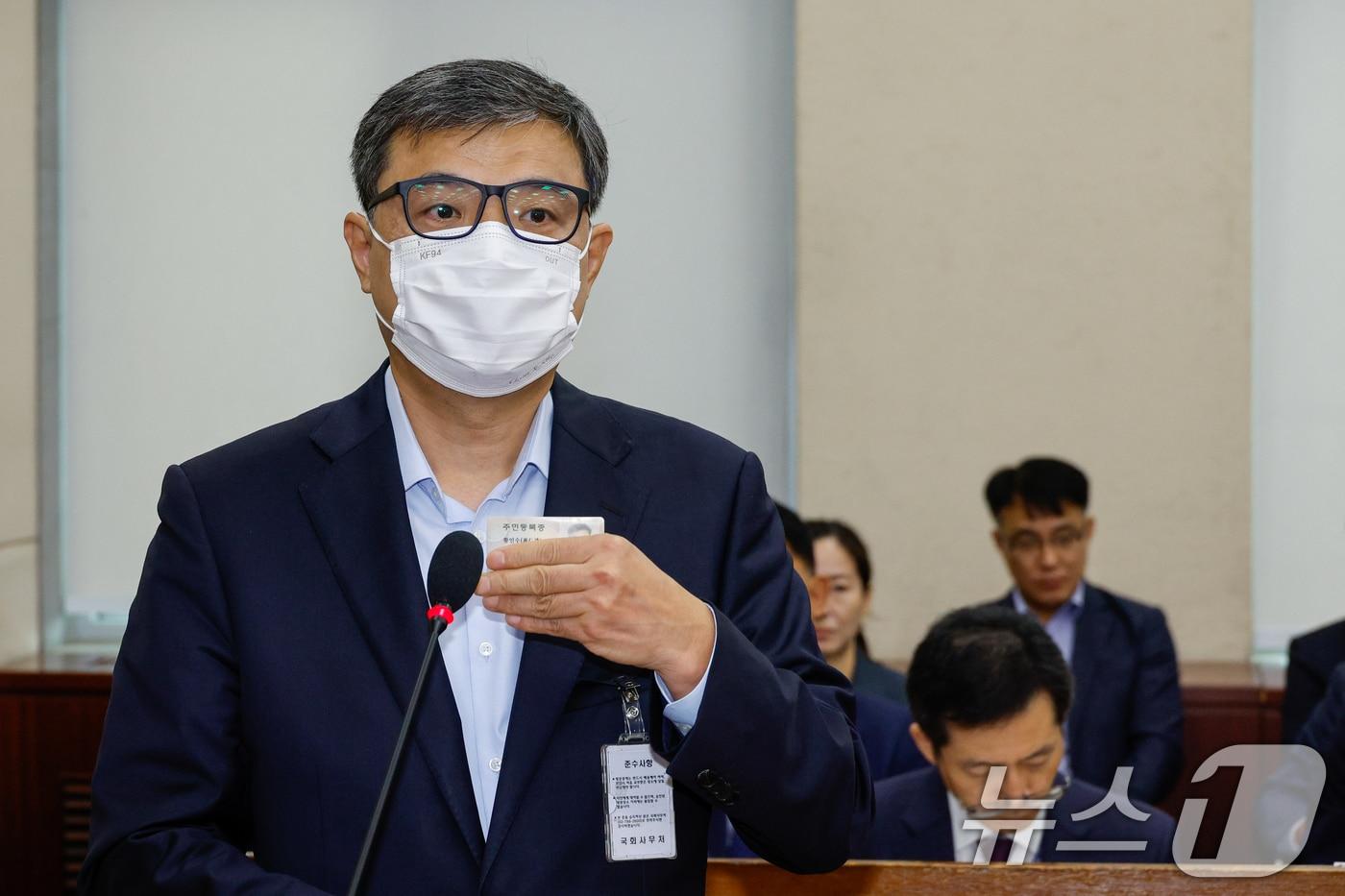 황인수 진실·화해를위한과거사정리위원회 조사1국장이 지난해 10월 10일 오전 서울 여의도 국회 행정안전위원회에서 열린 중앙선거관리위원회·진화위·소방청·한국소방산업기술원 국정감사에 출석해 마스크를 벗으라는 신정훈 행안위원장 명령을 거부, 자신의 신분증을 들어 보이고 있다. 2024.10.10/뉴스1 ⓒ News1 안은나 기자