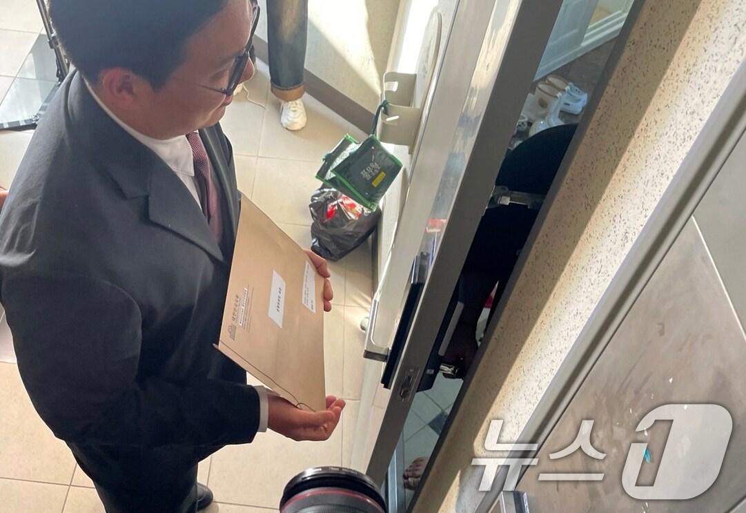 본문 이미지 - 국회 행정안전위원회 입법사무관이 동행명령장을 전달하기 위해 10일 오후 &#39;김건희 여사 공천개입&#39; 의혹 관련자인 명태균씨의 경남 창원시 성산구 자택을 찾아 명씨 가족과 대화하고 있다. 2024.10.10/뉴스1 ⓒ News1 강정태 기자