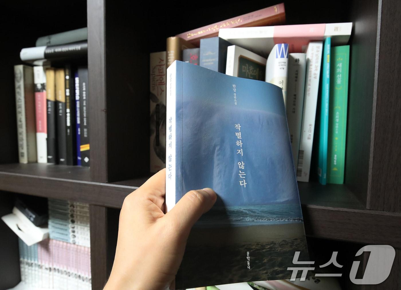 본문 이미지 - 한강 작가의 노벨문학상 수상 소식이 전해진 10일 오후 대구의 한 시민이 제주 4·3 사건의 비극를 다룬 한강의 대표작 &#39;작별하지 않는다&#39;를 꺼내고 있다. 2024.10.10/뉴스1 ⓒ News1 공정식 기자