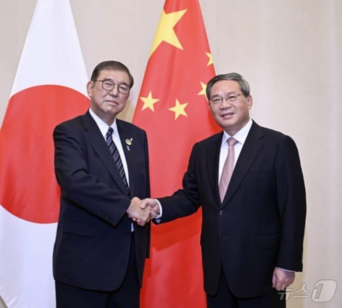 본문 이미지 - 라오스에서 악수하는 리창 중국 총리(오른쪽)와 이시바 시게루 일본 총리.(사진은 중국 외교부 홈페이지 갈무리)