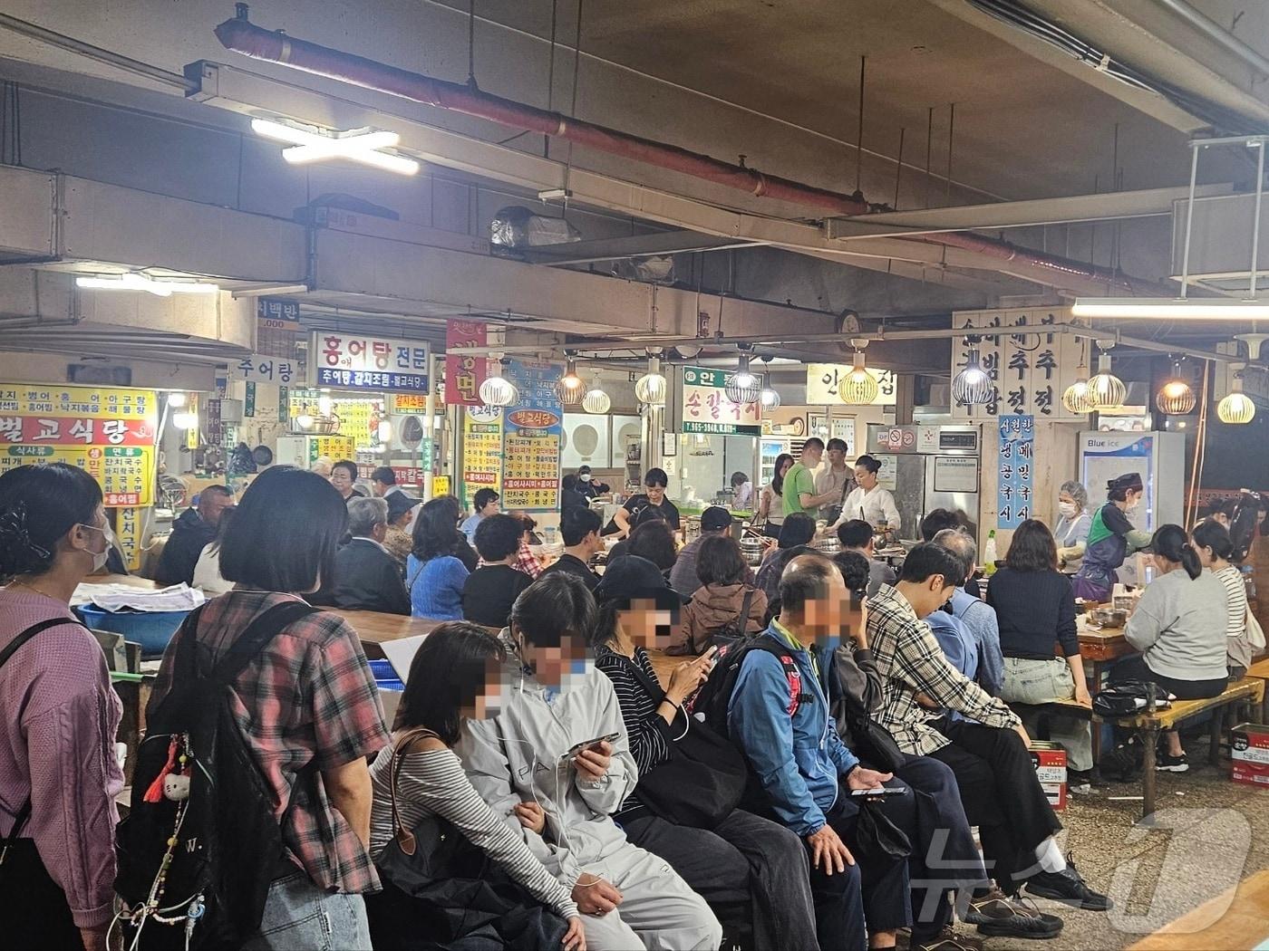 본문 이미지 - 넷플릭스 흑백요리사에 '이모카세1호'로 출연한 김미령 씨(49)가 운영하는 서울 동대문구 경동시장의 한 안동국시 가게. 11일 낮 12시쯤 찾은 가게 앞에는 60명이 넘는 긴 줄이 이어졌다. 2024.10.11/뉴스1 ⓒ뉴스1 장시온 기자