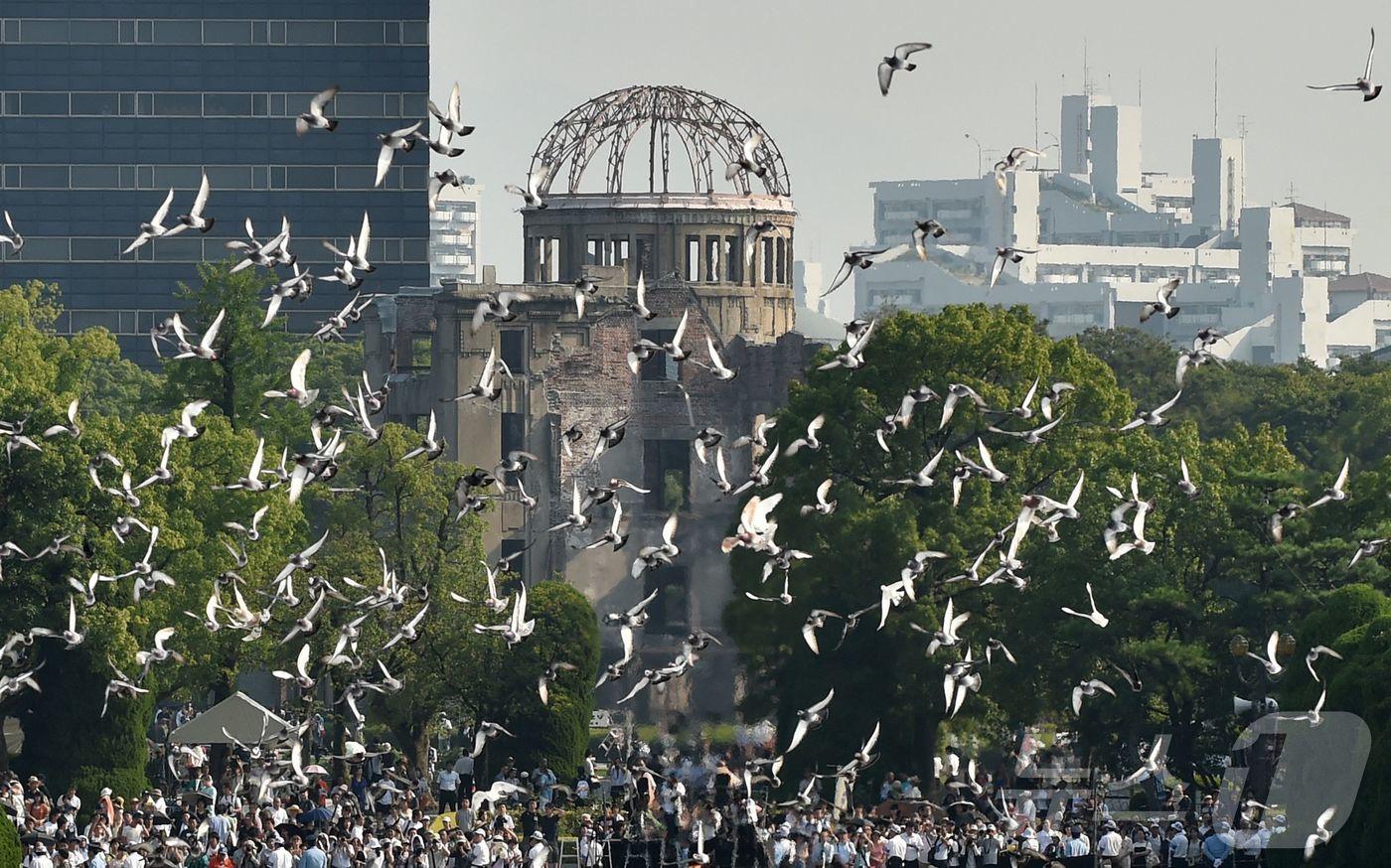 본문 이미지 - 일본 히로시마 평화기념공원 상공에 평화를 상징하는 비둘기들이 날아가고 있다. 2015.08.06/ ⓒ AFP=뉴스1 ⓒ News1 권진영 기자