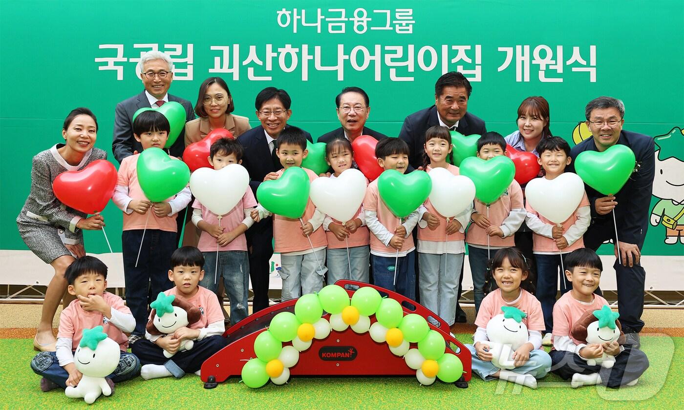 하나금융그룹은 지난 11일 충청북도 괴산군과 민관 협력으로 '국공립 괴산하나어린이집'을 개원한 가운데, 개원식에 참석한 강성묵 하나금융그룹 부회장(맨 뒷줄 왼쪽에서 네 번째)이 송인헌 괴산군수(맨 뒷줄 왼쪽에서 다섯 번째)와 어린이집 원장, 학부모, 어린이, 내외빈들과 함께 97번째 어린이집 개원을 축하하며 기념촬영을 하고 있다. 사진은 하나금융그룹 제공.